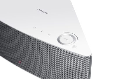 Trådløs, tilsluttet Samsung WAM551 højttaler i hvid, set ovenfra, med grå metalrist og central volumeknap