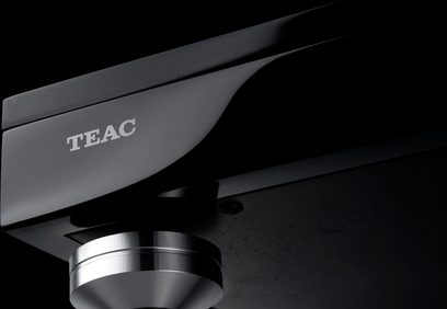 Sort TEAC TN-5BB pladespiller, nærbillede i dykning af tonearmen med pickup og det sølvfarvede logo på coveret