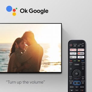 Par forelsket på stranden i solnedgangen, Panasonic TX-55JX940E fjernbetjening med knapper til Netflix, Prime Video, YouTube, Mine apps