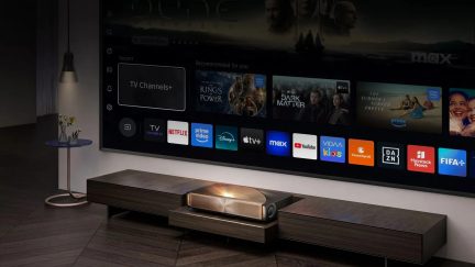 Hisense īpaši īsa fokusa videoprojektors, kas projicē straumēšanas saskarni uz liela sienas ekrāna