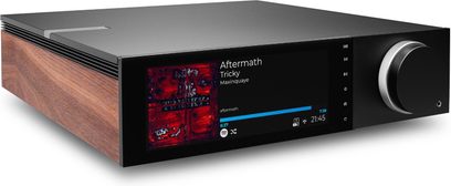 Amplificatore hi-fi integrato stereo Cambridge Audio EVO 150SE, chassis rettangolare in alluminio nero con fianco sinistro in legno impiallacciato, ampio schermo a colori e grande manopola argentata sul pannello frontale, vista da tre quarti anteriore sinistra