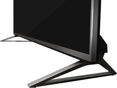Pé em V preto fosco e prateado de uma TV de tela plana, visto em close-up do perfil esquerdo
