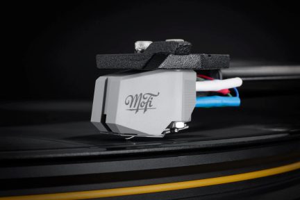 Pelēka MoFi fono galviņa, uzstādīta uz vinila atskaņotāja tonearma, adata uz melnas plates
