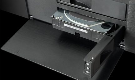 Harddisk indsat i et sort åbent kabinet, set i perspektiv, synlig etiket, metal- og plastoverflade