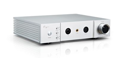 Compatto dispositivo audio in alluminio argentato, visto da tre quarti davanti a sinistra, con un lato scanalato, tre piccoli pulsanti rotondi, tre prese per cuffie frontali e un’ampia manopola del volume nera con bordo argentato
