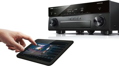 Sort Yamaha RX-A850 hjemmebiografsforstærker med sort front, display, knapper og stik. Hånd holder en touchplade