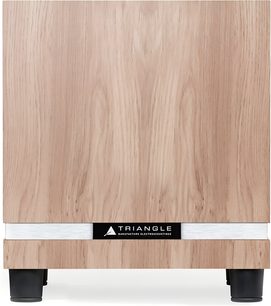 Triangle Thetis 300 subwoofer i lys eik med naturlig trestruktur, sett forfra, med sølvfarget metallbånd og sentrert logo nederst, stående på svarte sylindriske føtter