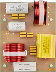 Circuito stampato con condensatori MCP 10,0uF±5% 250VDC, resistenze, bobine di rame rosso e giallo su sfondo verde