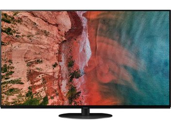 Nærbillede af en Panasonic TX-55HZ1000E tv-skærm, der viser et billede af en klippe og strand