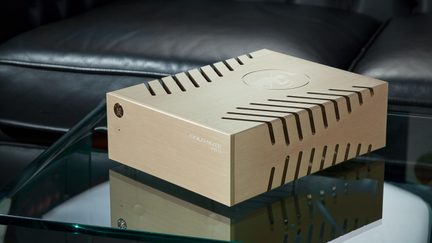 Zeltains alumīnija Gold Note PST-10 audio barošanas bloks ar ventilējamu dizainu, novietots uz stikla galda