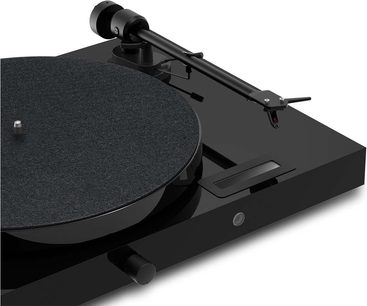 Pro-Ject Juke Box E1 yüksek kaliteli plak çalar, açıdan kısmi görünüm, siyah dairesel plak tablası, siyah okuma kolu, döner düğme