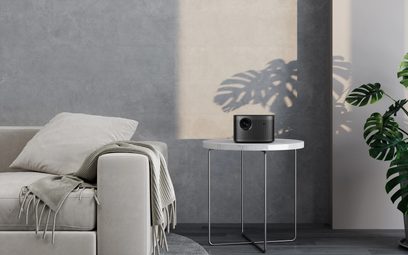 XGIMI Horizon Pro 4K hvid videoprojektor, set forfra, placeret på et hvidt sofabord foran en lysegrå sofa