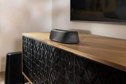 Rektangulær sort Polk Audio MagniFi Mini AX soundbar på træmøbel, set lidt fra siden forfra