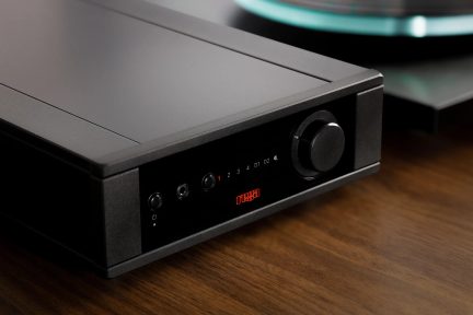 Black rectangular case with a front panel featuring a screen, 3 circular buttons, 1 dial, and red illuminated numbers