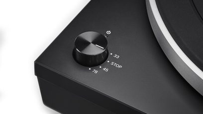 Sort Audio Technica AT-LP5X pladespiller, nærbillede i fugleperspektiv af kontrolknappen og den aluminiumstonearmen
