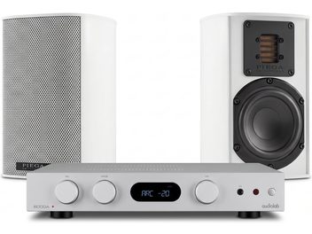 Amplificador Audiolab 6000A prateado com par de colunas Piega brancas, vistas frontais com grelha e altifalantes visíveis