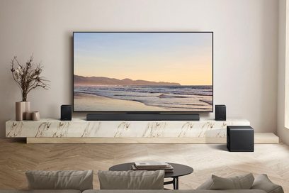 Černý matný soundbar s nepřerušovanou přední mřížkou, pohled zepředu, doplněný dvěma černými satelitovými reproduktory a přizpůsobeným krychlovým subwooferem