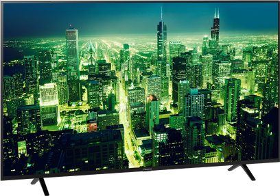 Panasonic TX-55LX700E-fladskærms-TV, der viser et natligt luftfoto af en oplyst by med talrige skyskrabere