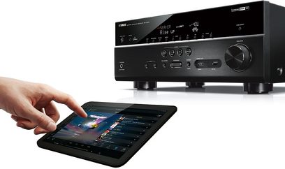 Yamaha RX-V679 sort hjemmebiografsforstærker, frontpanel, hånd rører ved touchskærm på tablet, der viser kontrolgrænseflade