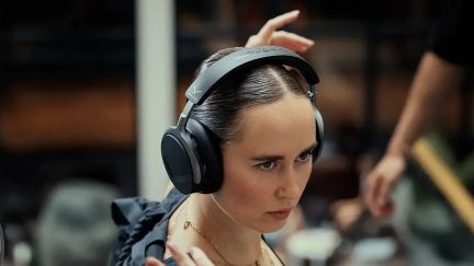 Sennheiser trådlösa svarta hörlurar med bred bygel, burna av en kvinna inomhus