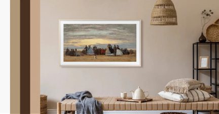 Ingelijste panoramische wanddecoratie, strandscène bij zonsondergang, boven een bank in een beige woonkamer