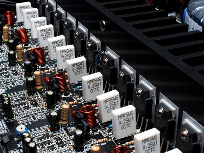 Printplader med elektroniske komponenter og MPRSW5 0.25ΩJ CCTC-kondensatorer monteret på en sort metalramme