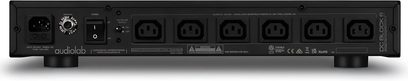 Condicionador de corriente Audiolab DC-BLOCK 6 negro con 6 tomas de corriente, 1 interruptor, 1 conector de entrada e inscripciones técnicas