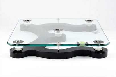 Relaxa Tablette 530 glas vibrationsdæmper, set ovenfra, rektangulært transparent glasplade, sort base med 4 justerbare fødder