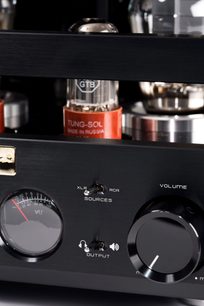 Preamplificatore per cuffie hi-fi Cayin HA-300MK2 nero in metallo spazzolato, vista frontale ravvicinata che mostra il VU-metro circolare, due interruttori a levetta, un'ampia manopola del volume lucida e valvole a vuoto a vista