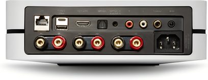 Integrovaný stereofonní hi-fi zesilovač BlueSound Powernode 2025 (N331) v bílém kovovém pouzdře, zadní pohled ukazující porty LAN a USB, HDMI eARC, optický vstup, RCA výstupy, čtyři páry červených a černých svorek pro reproduktory a síťový konektor