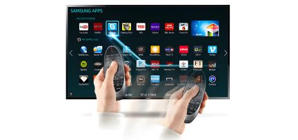 Handen houden een zwarte afstandsbediening vast met een scherm waarop aanbevolen Samsung-applicatie-iconen worden weergegeven