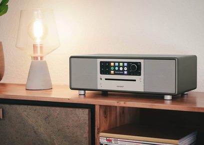 Sonoro Prestige graphite matte radio - silver, front view, placed on wooden shelf, lamp lit beside it