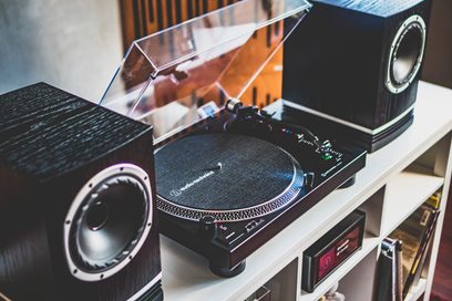 Audio Technica AT-LP120XBTUSB sort pladespiller, set ovenfra og forfra, låget åbent, vinylplade lagt på