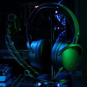 Herní sluchátka Audeze Maxwell Xbox zelená a černá, detailní pohled zleva na tmavém pozadí s modrými odlesky