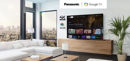 4K Ultra HD OLED-TV fra Panasonic med Google TV i en stue med hvid sofa og stort vinduesparti med udsigt over en by