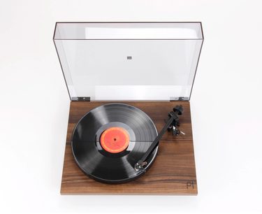 Hi-fi pladespiller Rega Planar 1 i lamineret træ, set forfra i et nedadgående perspektiv, låget åbent, sort pladespindel, tonarm