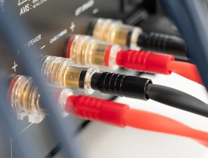 Luidsprekerklemmen van een audioversterker met rode en zwarte banaanstekkers in close-up