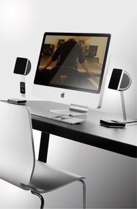 Sada reproduktorů 2.1 Focal XS pack 2.1 bílý obsahující dva satelitní reproduktory a subwoofer, umístěné na černobílém stole