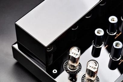 Cayin CS-6PH -hifi-tehovahvistin, kiiltävän musta metallirunko lähikuvassa ylhäältä päin, suorakulmainen kiiltävä muuntajakotelo ja kaksi lasista elektroniikkaputkea pyöreillä kannattimilla