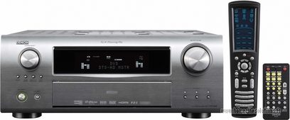 Denon AVR-2808 sølvfarvet hjemmebiograf-forstærker, set forfra, blåt display, sølvfarvede knapper og drejeknapper, sort fjernbetjening