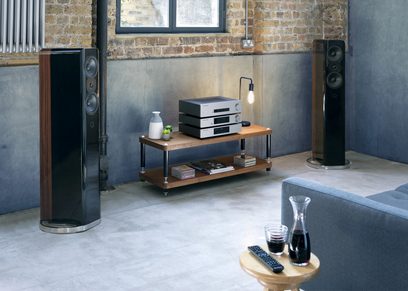 Cambridge Audio CXA81 stereoforstærker i antracitgrå med sølvfinish, højttalere, træ-TV-møbel, murstenvæg, trægulv