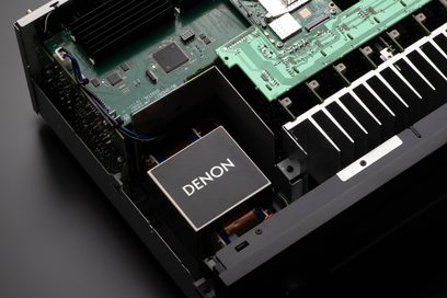 Vista interna di un amplificatore Denon AVC-X4800H argento che mostra i circuiti stampati verdi e i componenti elettronici