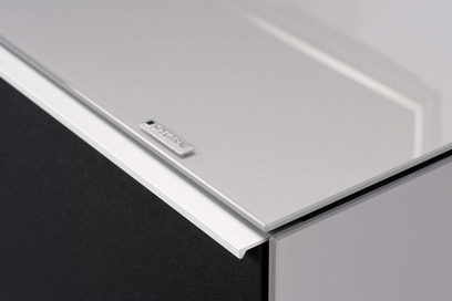 Spectral Scala SC1100 hvidt audio-/videomøbel, nærbillede fra en vinkel, glat, blankt materiale, metalskilt med logo