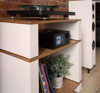 NAD C700 V2 black stereo hi-fi amplifier on wooden shelf, screen on, turntable above, white speaker to the right