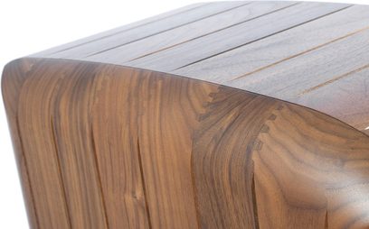 Boîtier brun en bois de noyer poli, gros plan en angle sur le coin supérieur arrondi avec fines rainures parallèles sur la surface supérieure