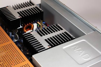 Sølvfarvet NAD M2 stereo hi-fi-forstærker, tæt ovenfra-billede af de interne kølelegemerne og elektroniske kredsløb