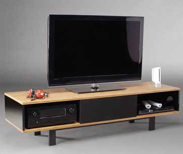 Lyst træmøbel til TV med to sorte rum til audio-/videoudstyr, en fladskærm og tilbehør ovenpå
