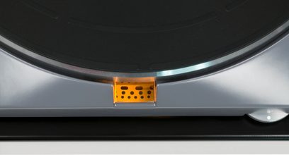 Thorens TD 124 DD vinil plak çalar, alt kısım yakın çekim, turuncu kapsüllü okuma kolu, cam plak tabak