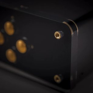 Forgyldt 6,35 mm jackstik på sort metalbagpanel af elektronisk enhed, nærbillede i let fugleperspektiv