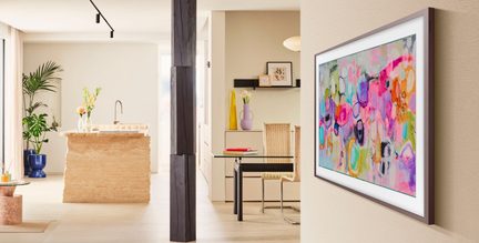 Tabella incorniciata con illustrazione astratta multicolore, vista laterale, cornice sottile rettangolare grigia su parete beige